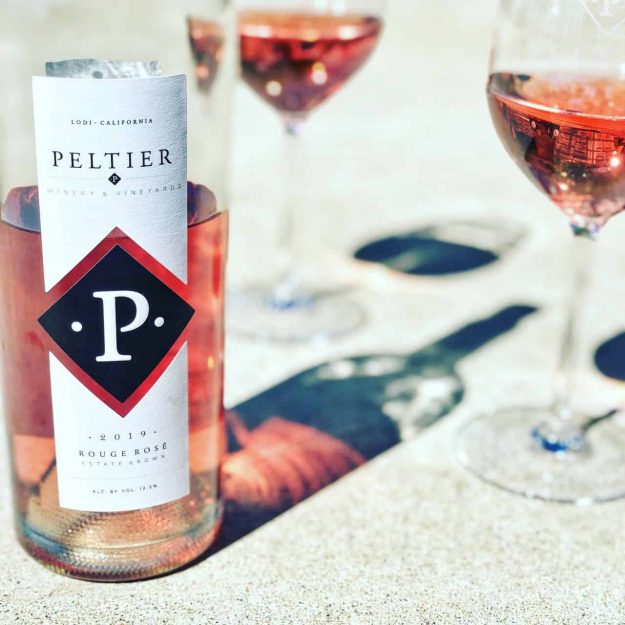 bottle of rouge rose wine with two glasses