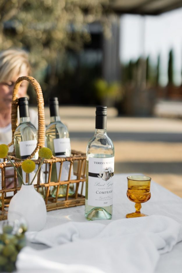 Bottle of marengo Pinot grigio on a white tablecloth with yellow glass outside