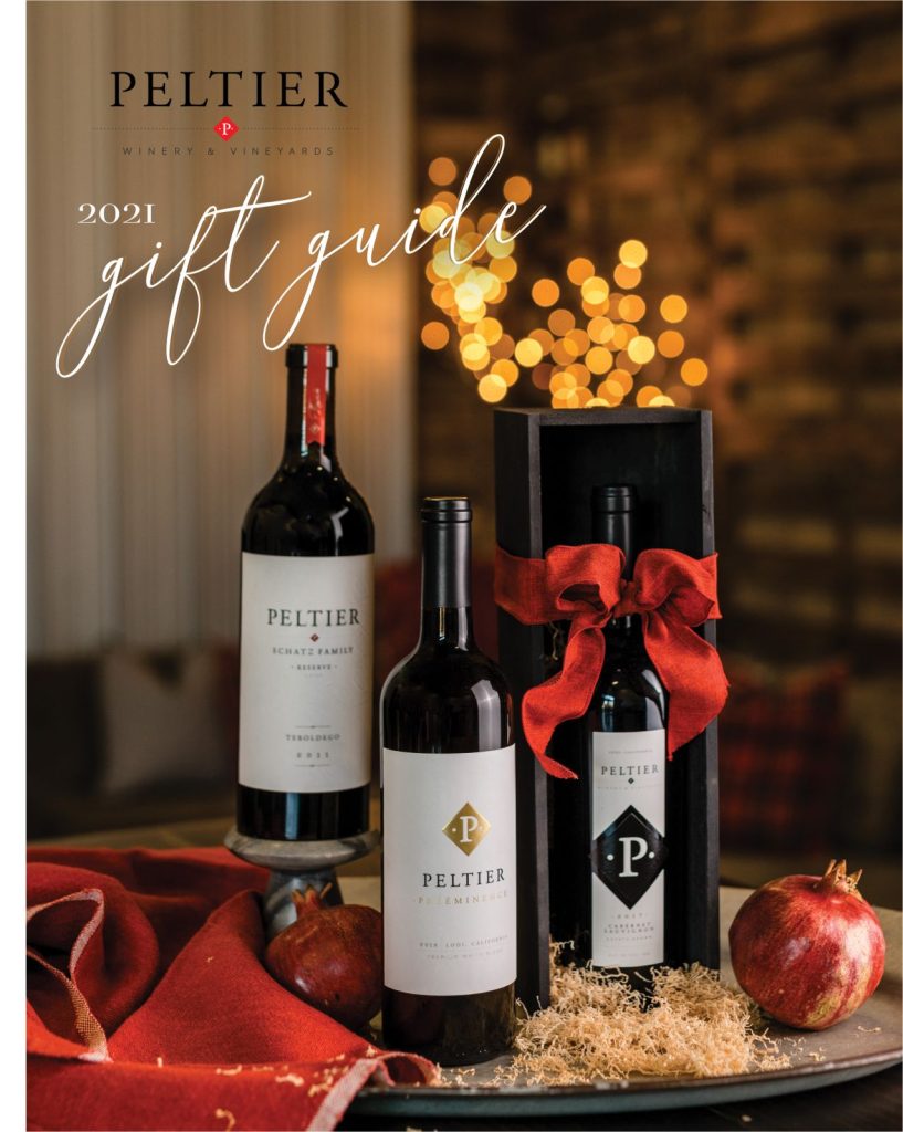 gift guide cover page with 3 wine bottles on a tray with red napkin and twinkle lights in background