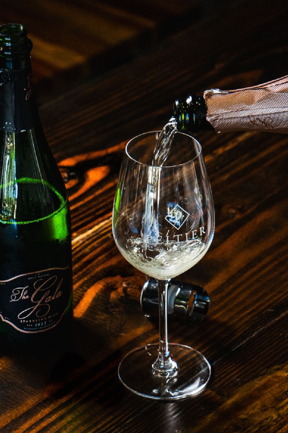 pouring sparkling wine into glass with bottle next to another glass pouring sparkling wine into glass with bottle next to another glass